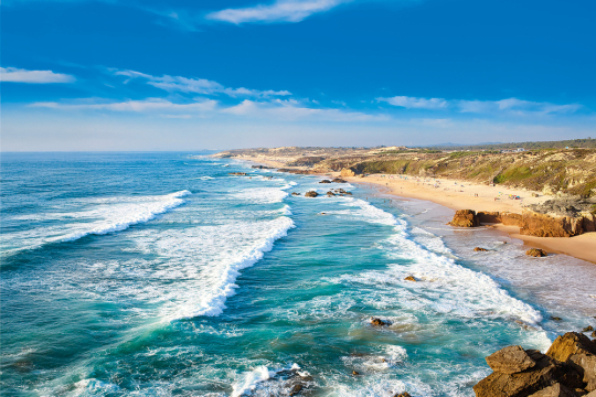 Küstenabschnitt in Portugal, rechts die felsige Küste, links das Meer